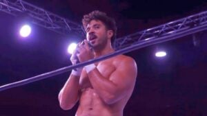 Max Caster speaks to the crowd on a microphone in the ring