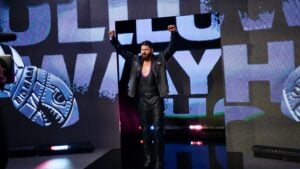 Sam Holloway raises both fists during his entrance with his name on the screens behind him