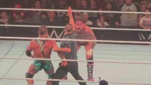CM Punk points skyward as the referee holds back Chad Gable during their match at the WWE live event in Youngstown
