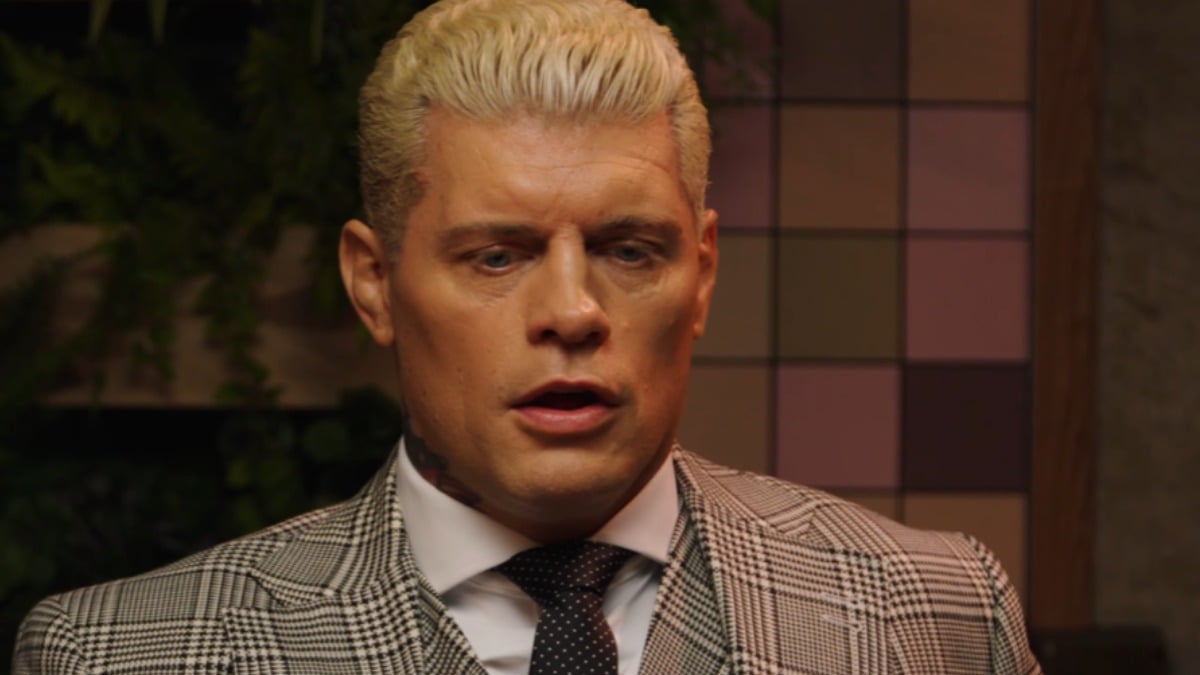Cody Rhodes in a grey plaid suit and dotted tie during an interview