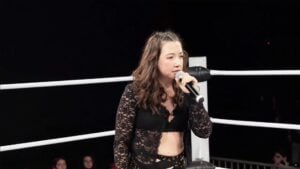 Sherilyn Guerrero, daughter of Eddie Guerrero, holds a microphone in the Reality of Wrestling ring